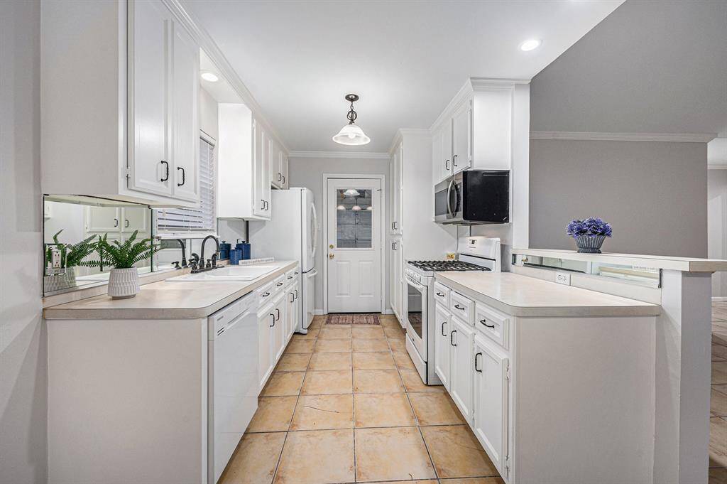 Functional kitchen with dishwasher, microwave, gas cooking, refrigerator, pantry. Door to garage.