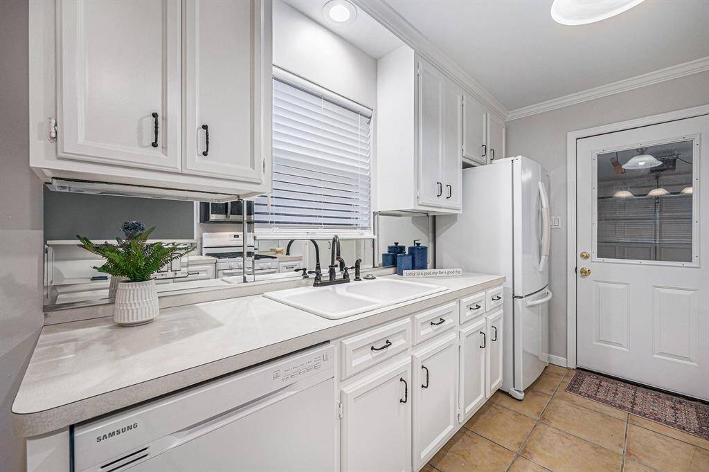 Another view of the kitchen with mirrored backsplash, new blinds, great lighting.