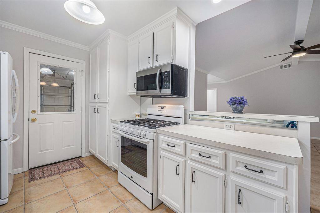 Opposite view of kitchen. New microwave, gas range, large pantry