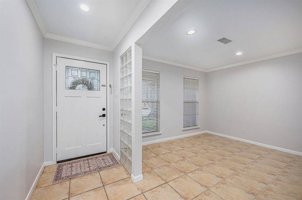 Room to left, as you walk in , facing the front of the home. recessed lighting, new blinds, tile flooring, crown molding.