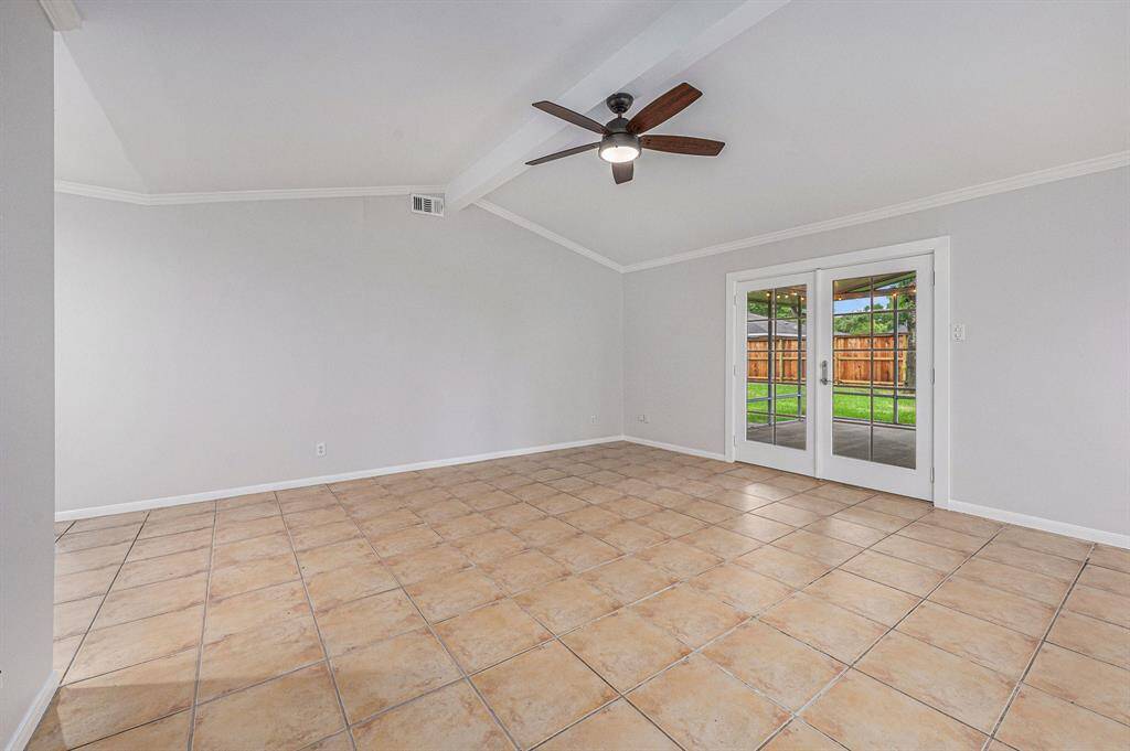 Here is the large family room with high ceiling, fan and access to the screened patio.
