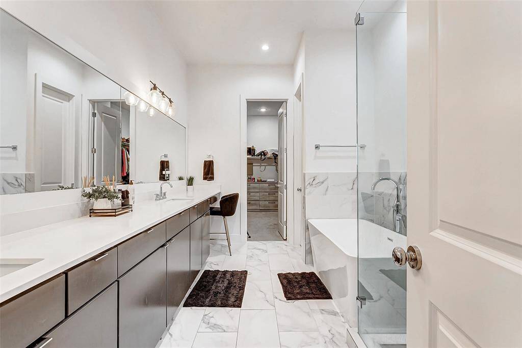 Spa style en-suite bath with double vanities, soaking tub and glass shower.