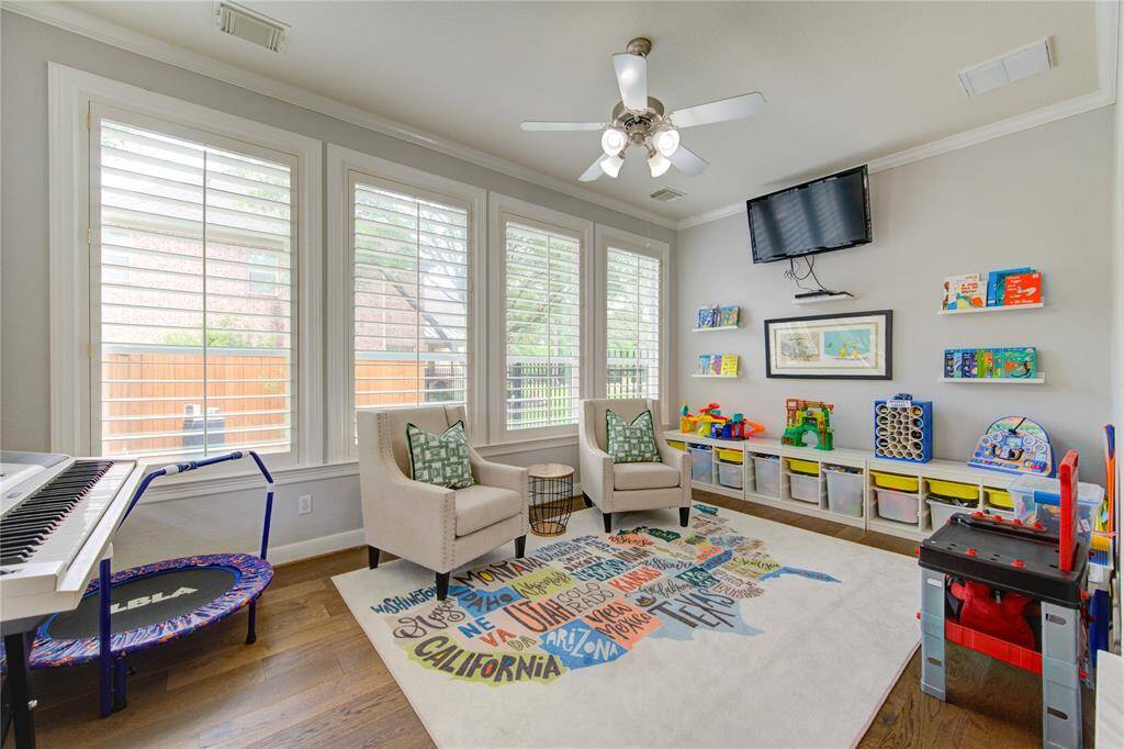 Sun-drenched flex space with wall-to-wall windows and plantation shutters—perfect as a playroom, homeschool area or cozy reading nook