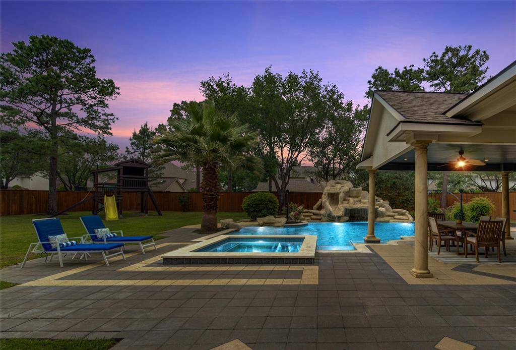 Resort-style backyard featuring a sparkling pool, lush landscaping, and multiple lounging zones—true outdoor luxury