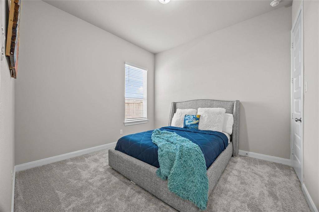 A cozy bedroom down stairs next to the full bath with neutral walls and carpet, is located downstairs. Could be used as an office as well.