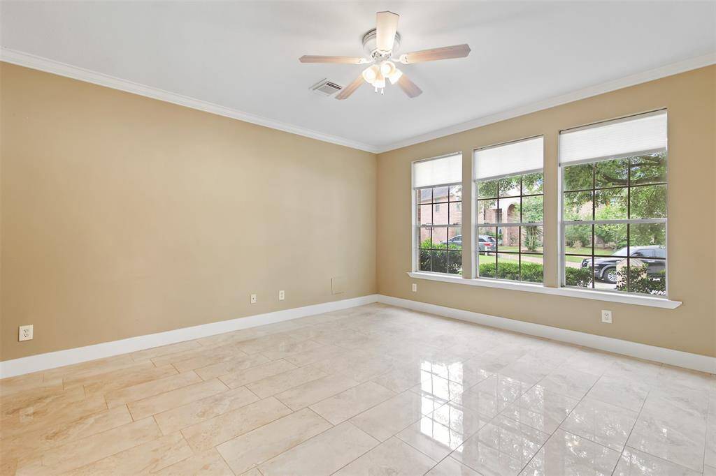 Primary bedroom features tile floors, ceiling fans and picture windows.