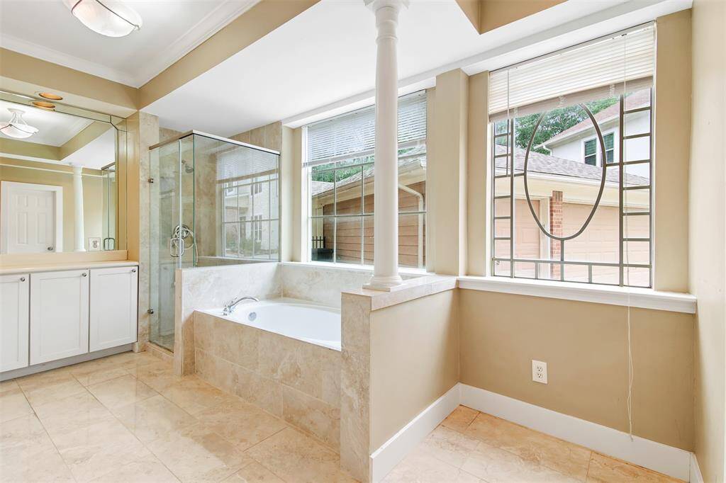 Primary bathroom features separate glass door walk in shower and garden tub.