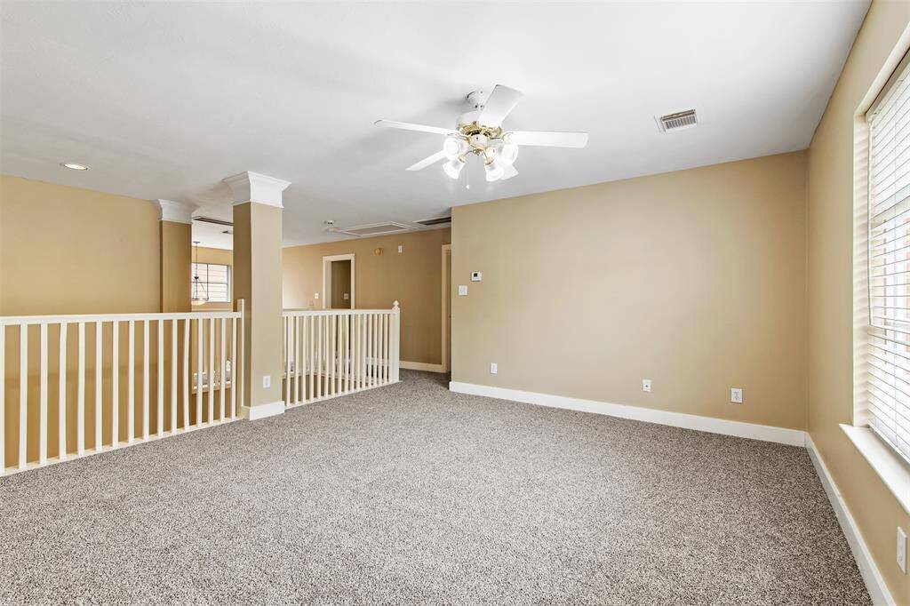 Gameroom upstairs has carpet and ceiling fan.