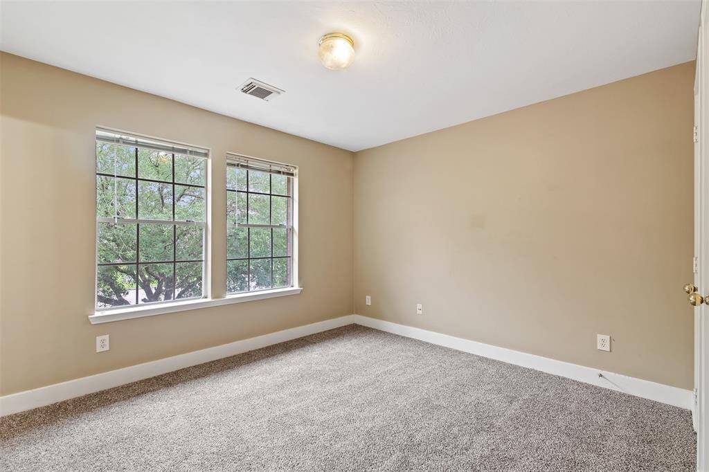 Additional secondary bedroom upstairs with carpet and picture windows.