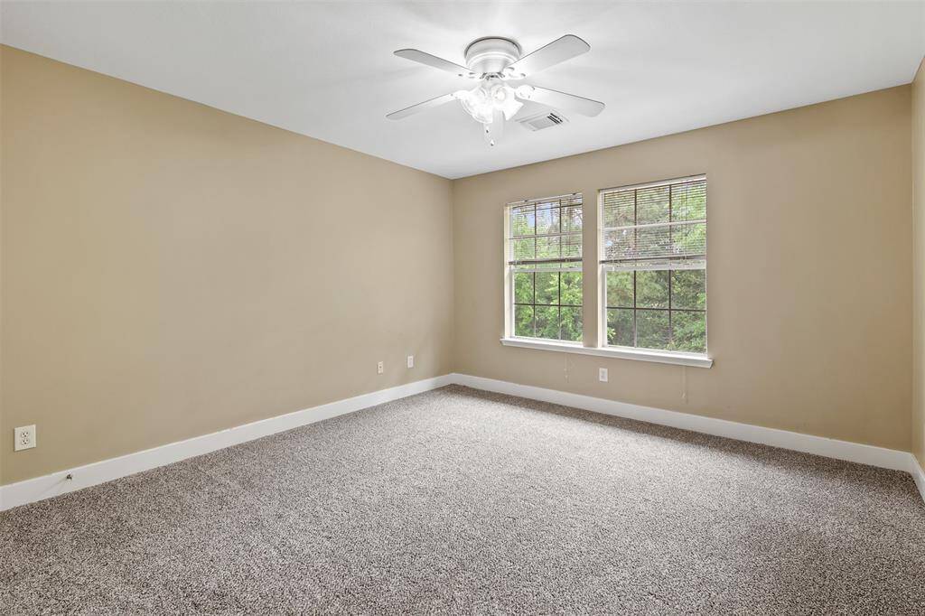 Another secondary bedroom upstairs with carpet and ceiling fan.