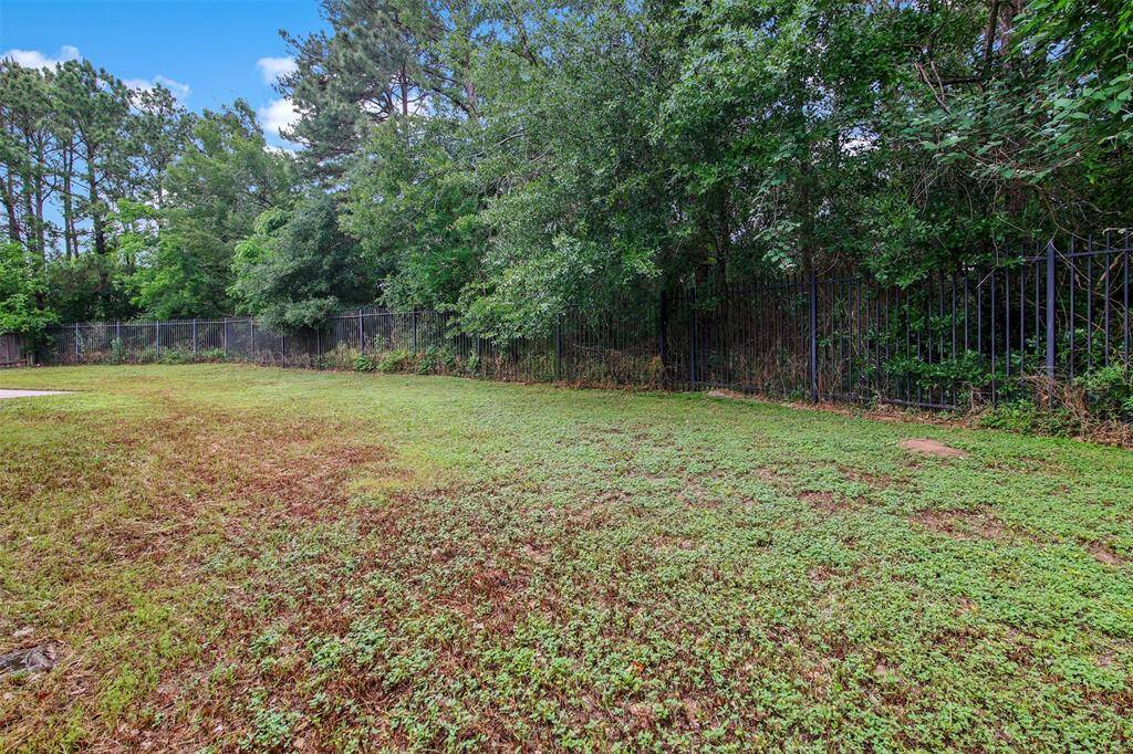 View from the backyard of the wooded area behind the fence for plenty of privacy and no back neighbors.