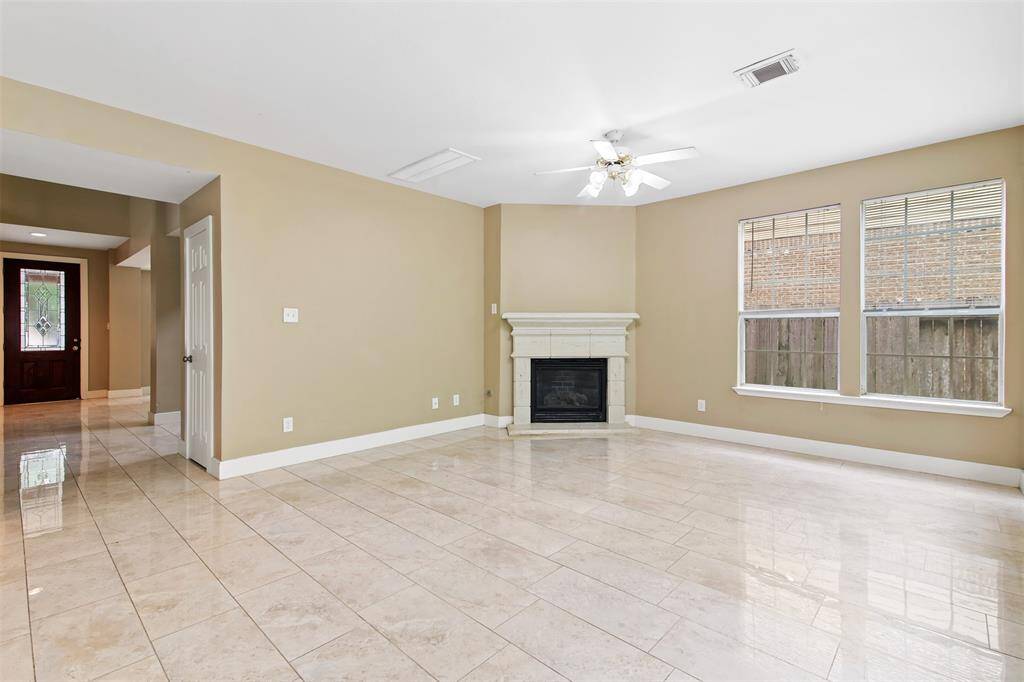 Family room features tile floors and fireplace with mantle.