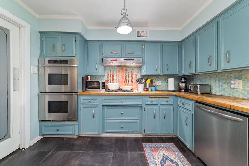 Wraparound kitchen design provides ample counter space and a practical layout. Retro-inspired cabinets offer both style and substance.