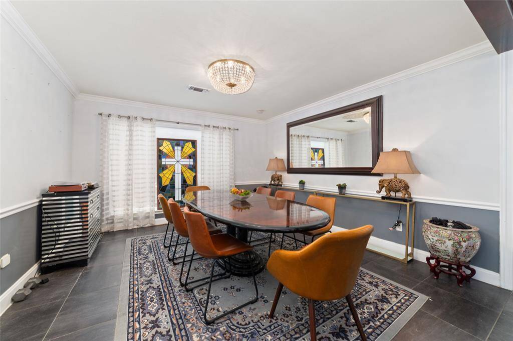 Formal dining room with designer lighting and backyard access. This space bridges indoor comfort with outdoor living.
