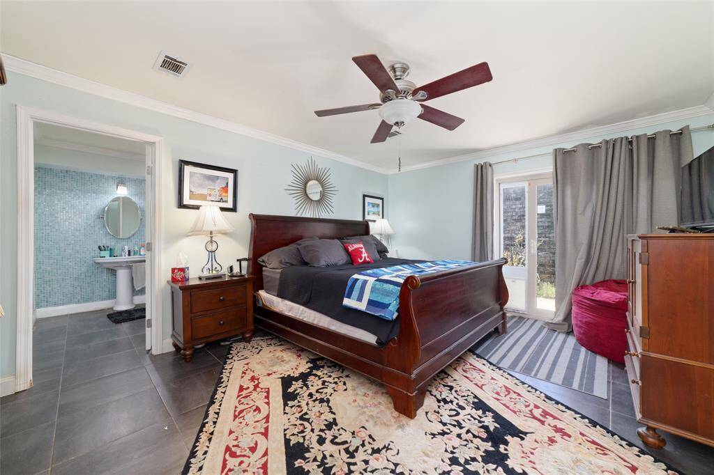 Primary bedroom with ceiling fan and large windows. Spacious and serene, it’s a true retreat at the end of the day.