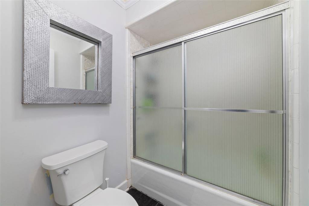 Hall bath with tub/shower combo and classic tile finishes. Clean, bright, and move-in ready.