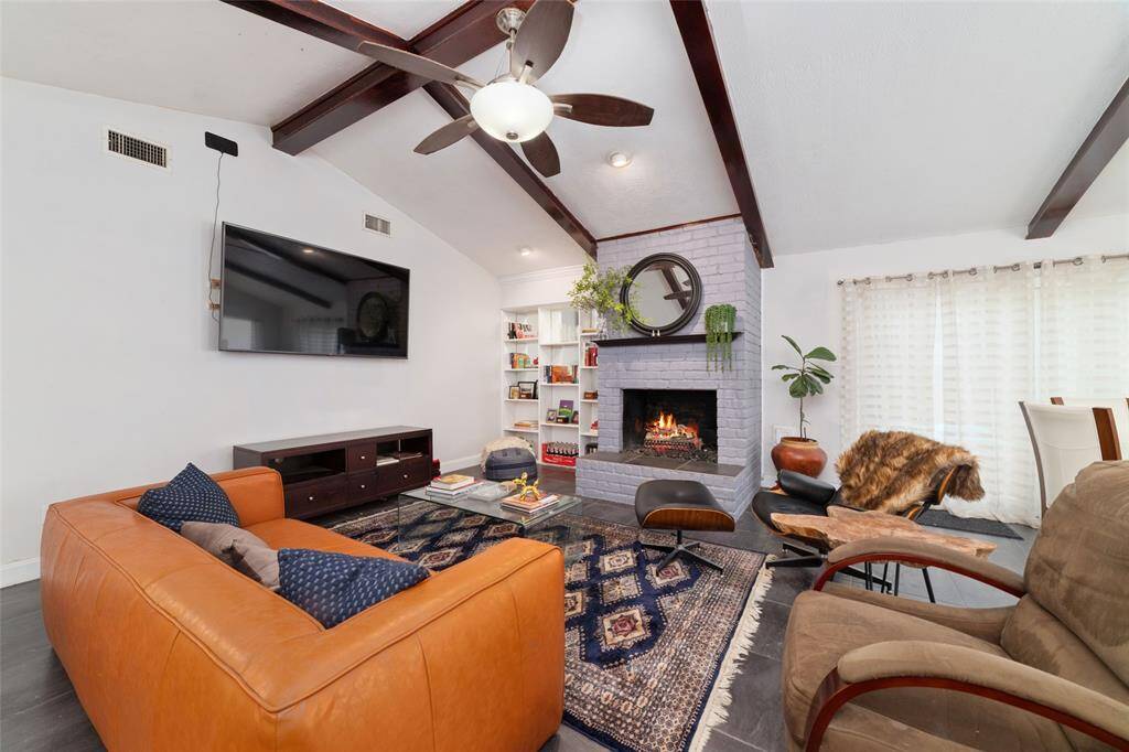 Comfortable and elegant living space anchored by a wood-burning fireplace. Natural light pours in, highlighting the warmth of the room.