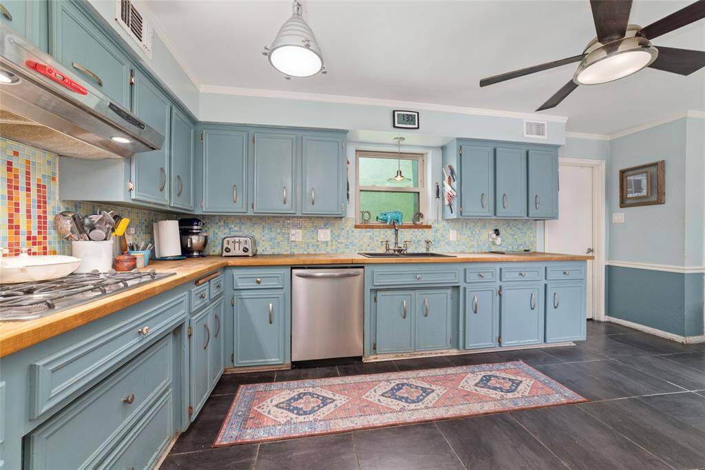 Chef’s kitchen with butcher block countertops, custom cabinetry, and updated appliances. It's both functional and full of personality.
