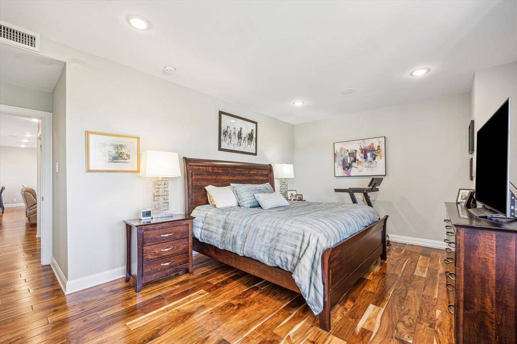 The spacious primary bedroom easily accommodates a king-size bed, with large windows, electric shades, and tranquil views creating a peaceful retreat.