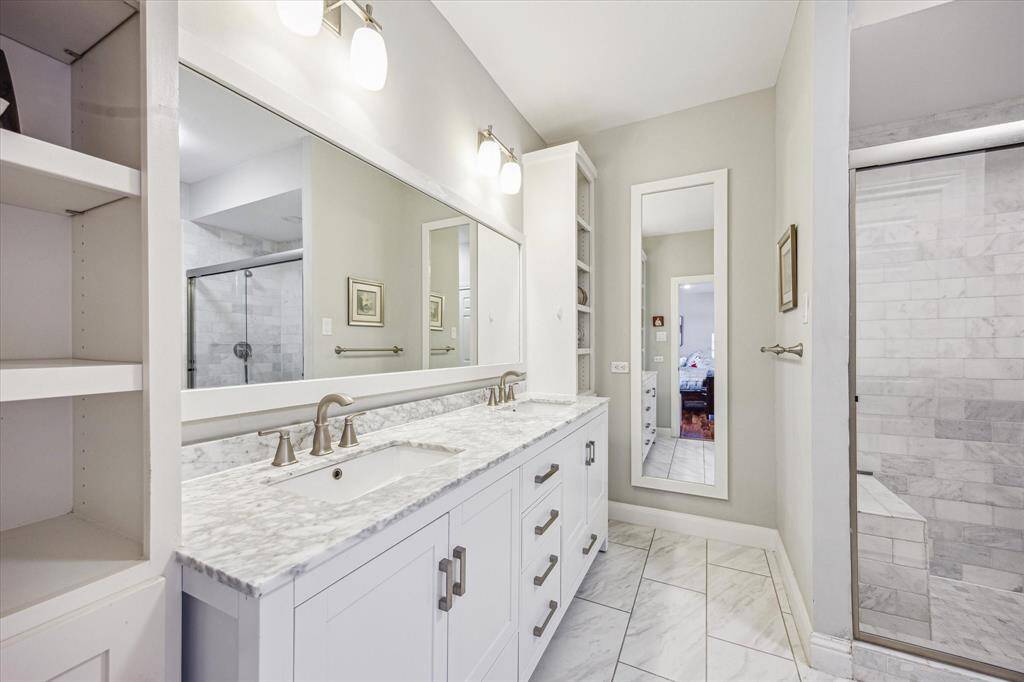 The serene primary bath features calming neutral tones, double sinks, and ample storage—combining elegance with everyday functionality.