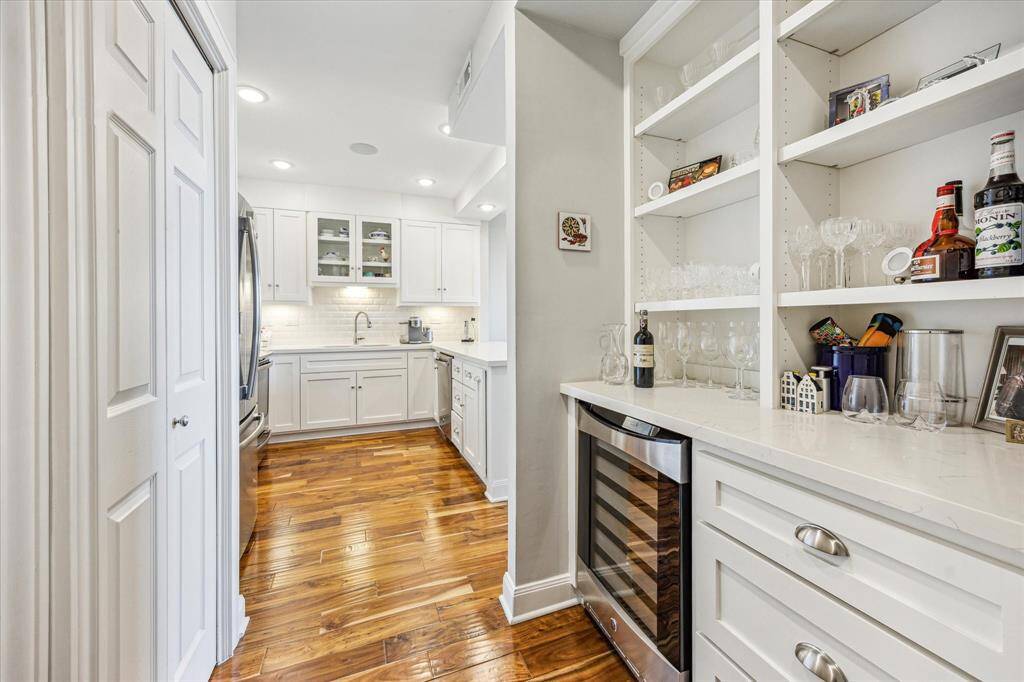Just off the kitchen, a stylish dry bar offers additional counter space and features a built-in wine refrigerator—perfect for entertaining.