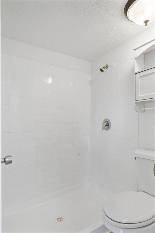 This bathroom features a clean, The space is bright and modern, with a simple overhead light fixture.
