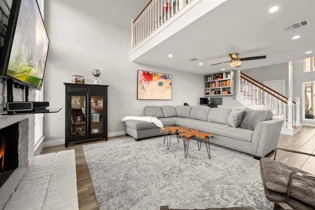 This living room is very elegant. The large, tall windows allow abundant natural light into the space and provide a stunning view. The fireplace is a lovely focal point for this room.