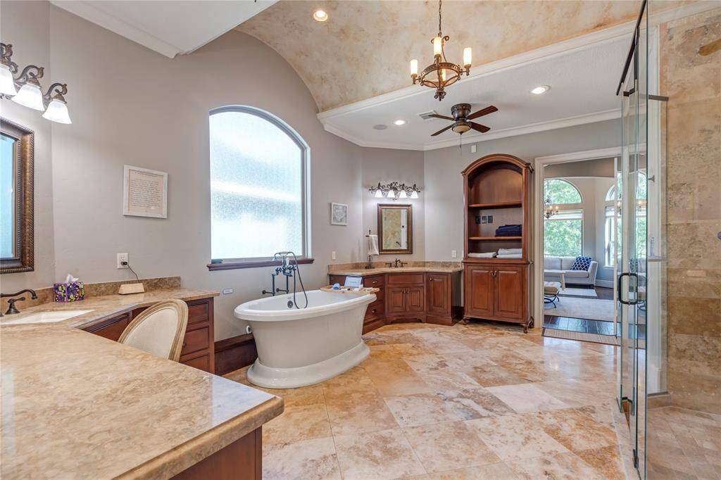 Primary bathroom with free standing tub. His and Hers sinks with a vanity area.  His and hers WC's and large shower.