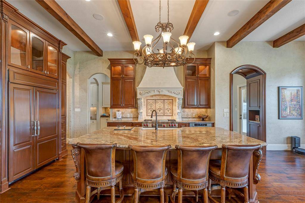 Sub Zero Refrigerator to the left with wooden cover.  Plenty of cabinets alone with a large Butler's pantry.