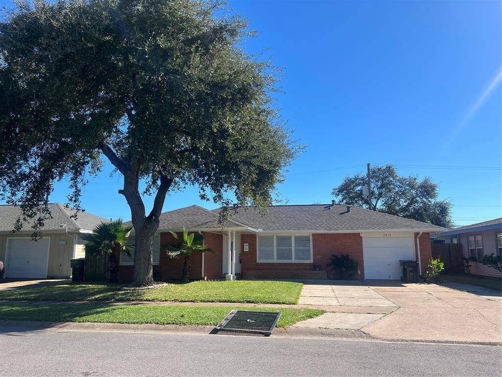 Front of house with mature tree.