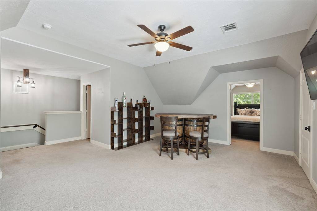 This upstairs full bath includes a tub/shower combo with tile surround, large vanity with sink, and commode.