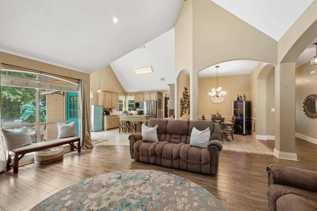 View from the fireplace looking back towards the breakfast room, kitchen, and formal dining space. The large arches and angled ceilings give this home a lot of architectural interest. The open concept floor plan makes this the perfect home for everyday living and for entertaining.