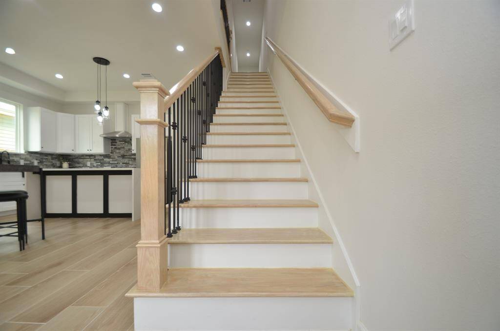 Elegant wood plank stairs with stylish wrought iron accents. All bedrooms are upstairs.