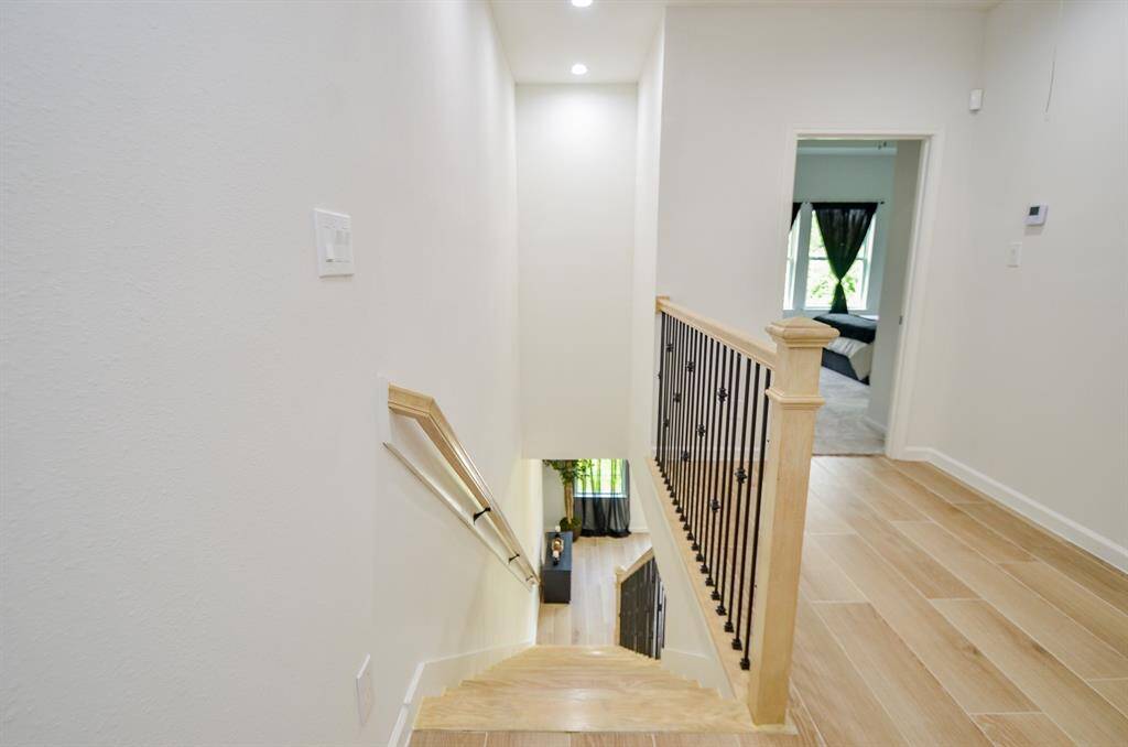 Common area upstairs also features neutral wood plank tile.  Notice the 10 foot high ceilings continue throughout the upstairs as well.