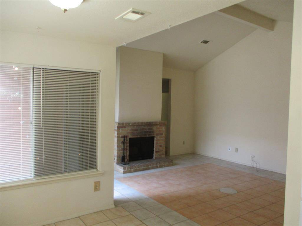 Hi ceilings and nice tile pattern in the living room with fireplace