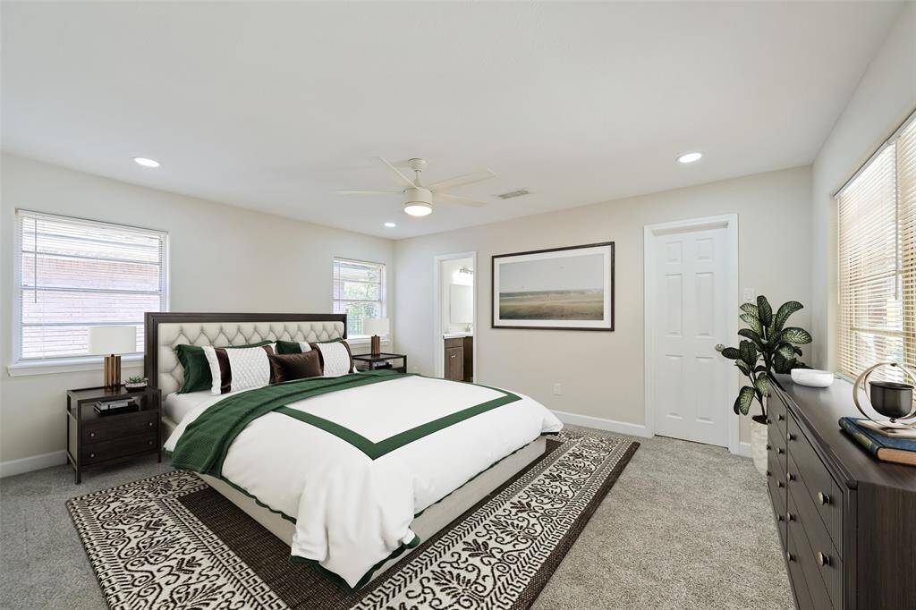 The primary bedroom features both a fan and recessed lighting, a walk in closet, and tons of natural light