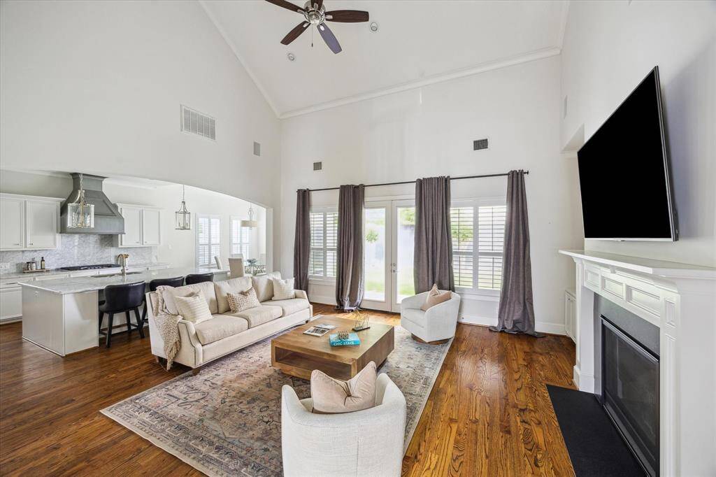 Airy family room with vaulted ceilings and French doors, seamlessly connected to the kitchen and breakfast area for an open-concept flow.
