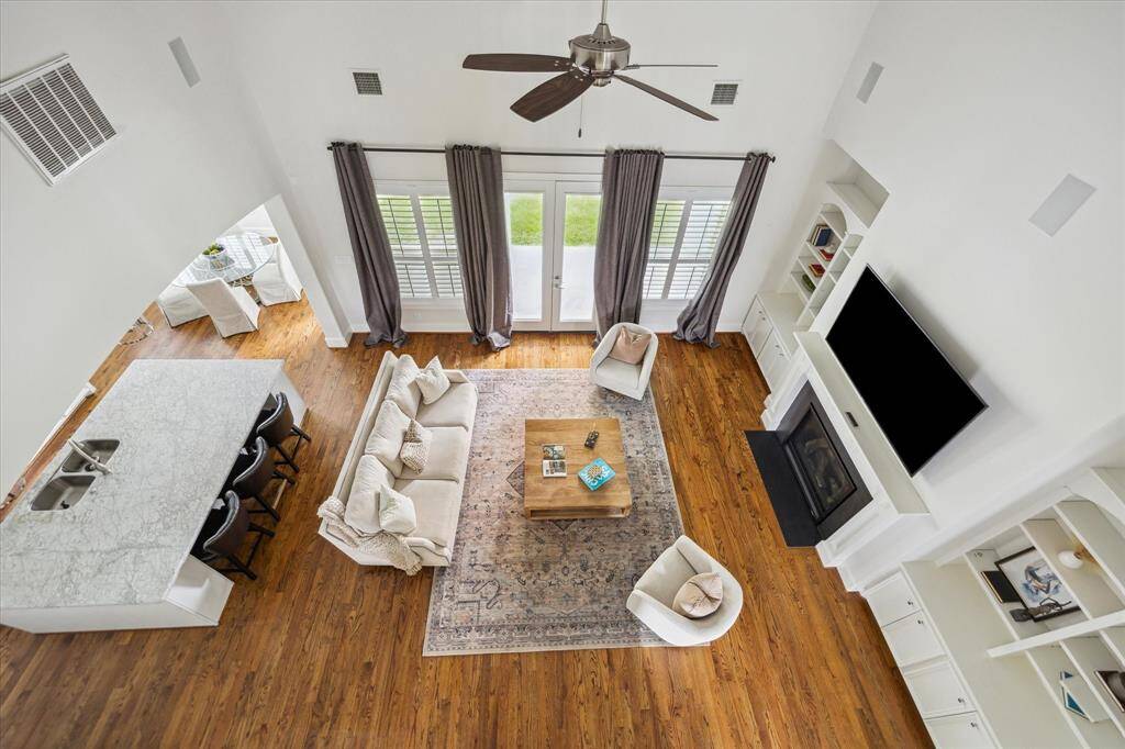 Overhead view of the family room highlights the open layout, vaulted ceilings, built-in shelving, fireplace, and seamless flow into the kitchen and breakfast area.