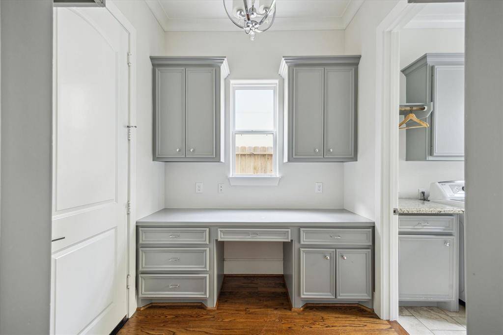 Built-in workstation in the mudroom features a wide counter, ample cabinetry, and natural light from a central window—ideal for organizing or home management tasks.