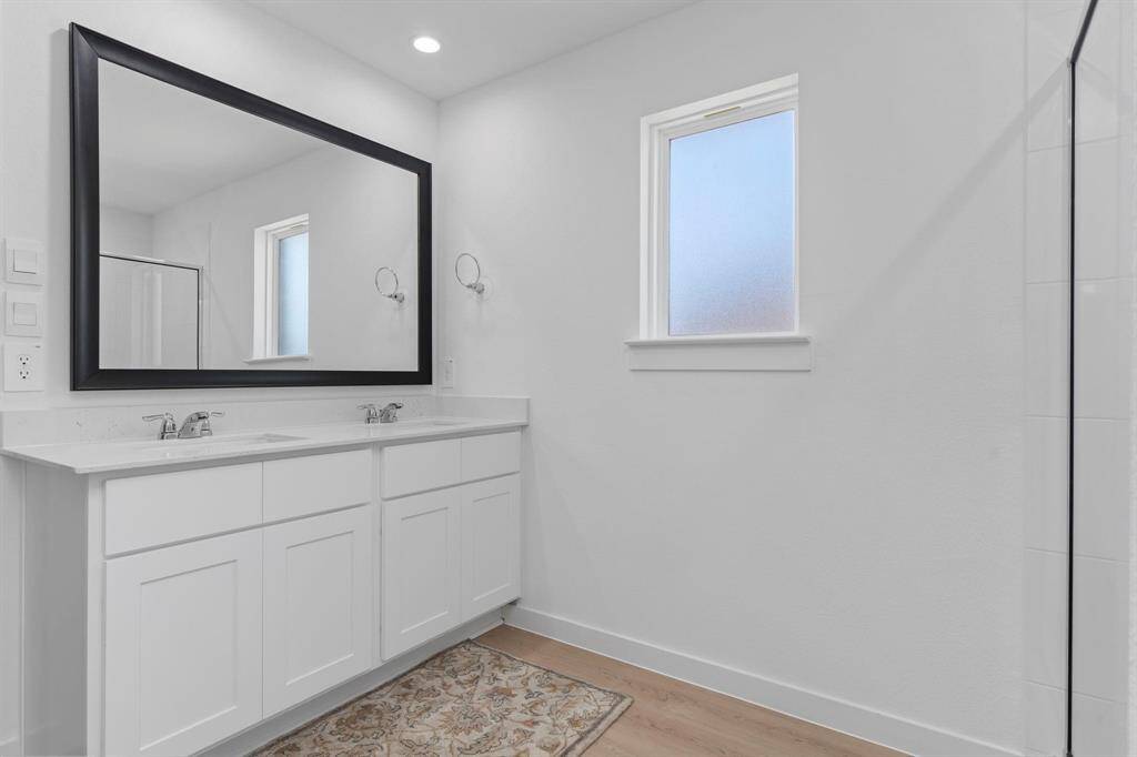 Primary bathroom with dual vanities and large walk in shower. All photos are representative of the home