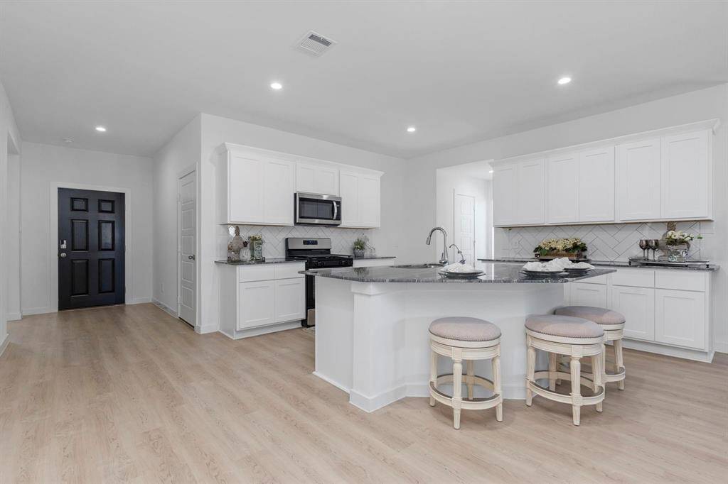 Kitchen area with modern touches and ample cabinet space. All photos are representative of the home