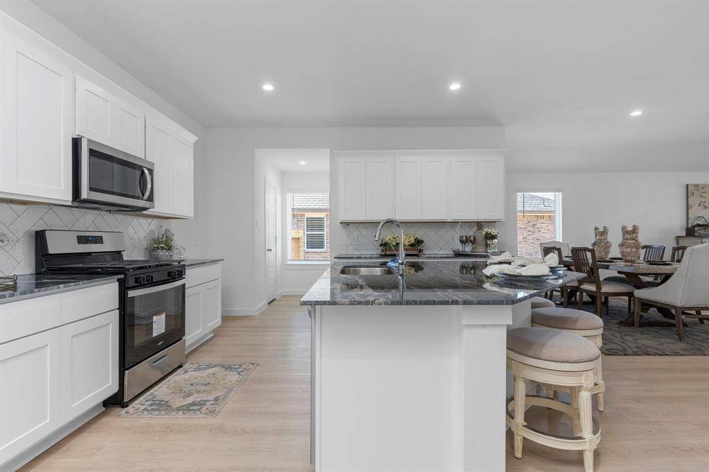 Kitchen area with modern touches and ample cabinet space. All photos are representative of the home
