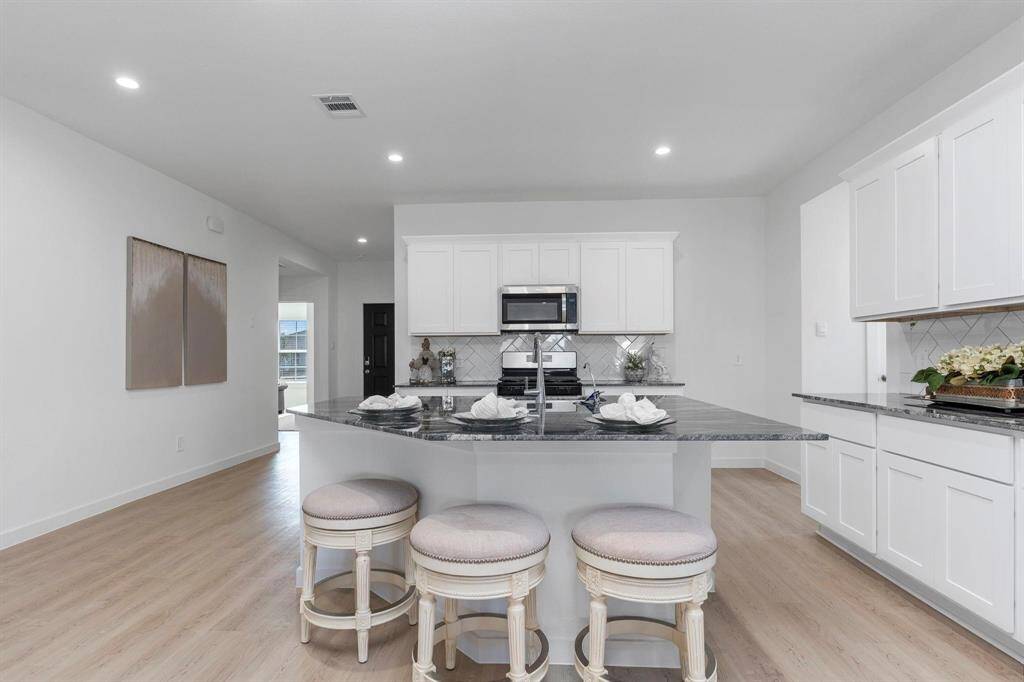 Huge island space in the kitchen. Kitchen area with modern touches and ample cabinet space. All photos are representative of the home