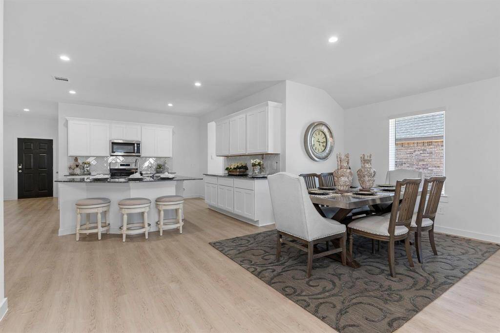 Dining area open to the living room and kitchen. All photos are representative of the home