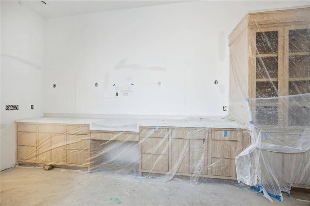 The Primary Bathroom offers double vanities with light sconces, Brizo plumbing, and white oak cabinetry with quartz countertops.