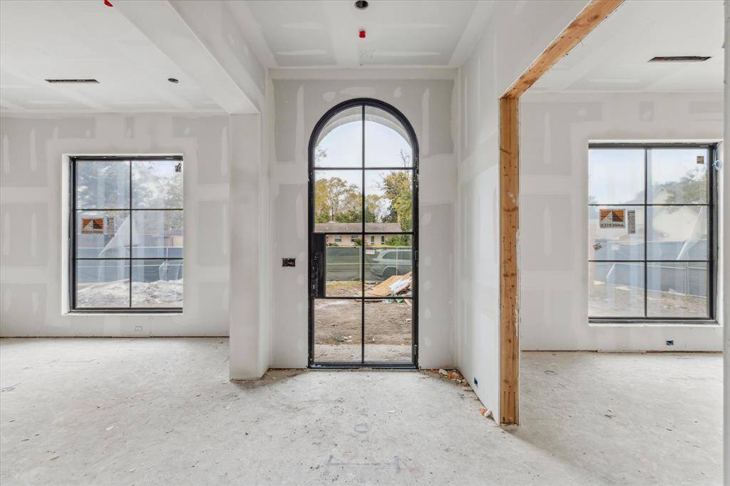 This stunning arch door is a modern statement of elegance while also flooding the home with natural light. Adjacent to the foyer are the dining room and private study. Progress Picture March 2025.