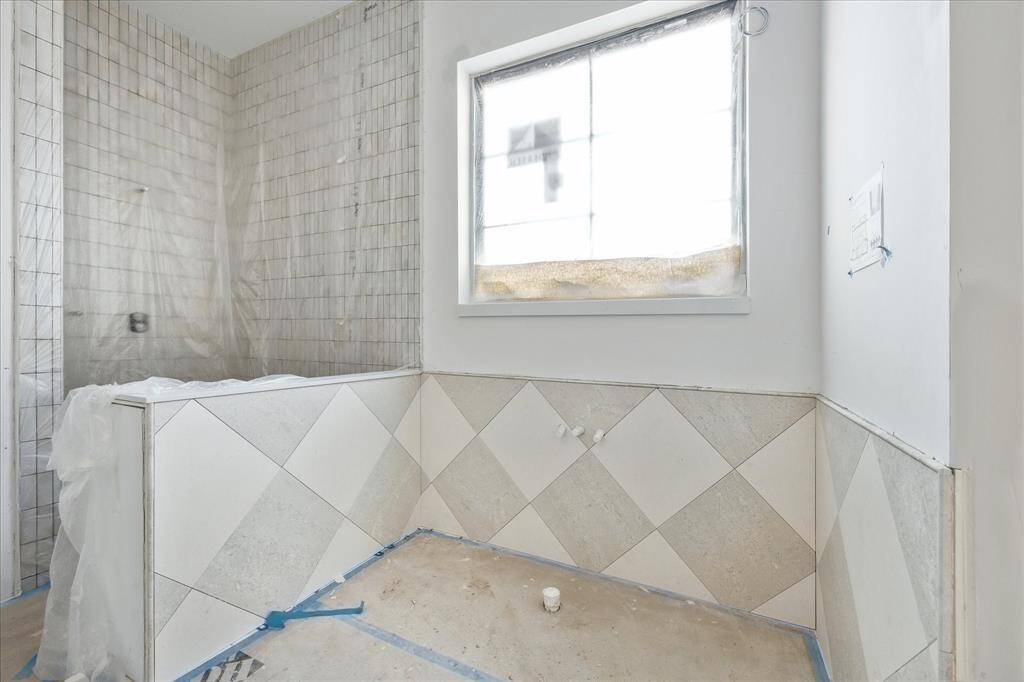 The primary bath to have Brizo plumbing, standalone tub, frameless glass enclosure, and natural stone flooring.