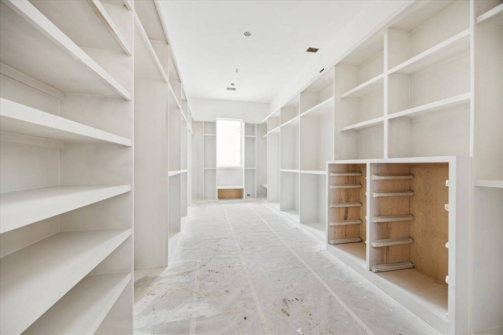Amazing primary closet with double chest, plenty of hanging, storage and custom cabinetry.