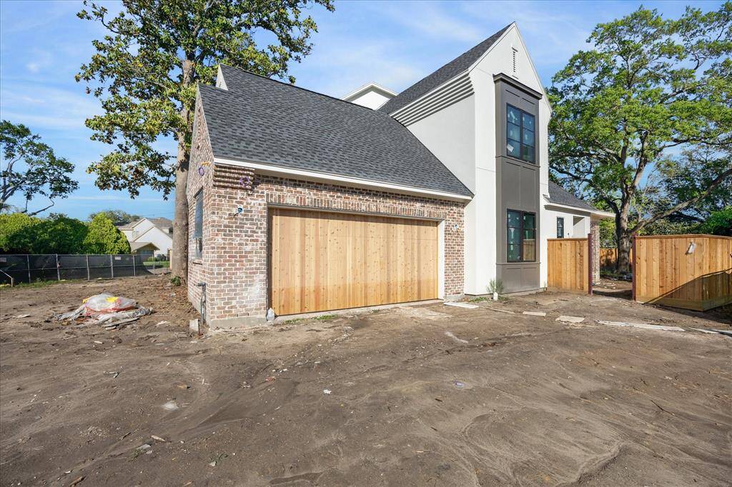 Side elevation with custom garage wood door, beautiful architectural elements and oversized front and back yards!