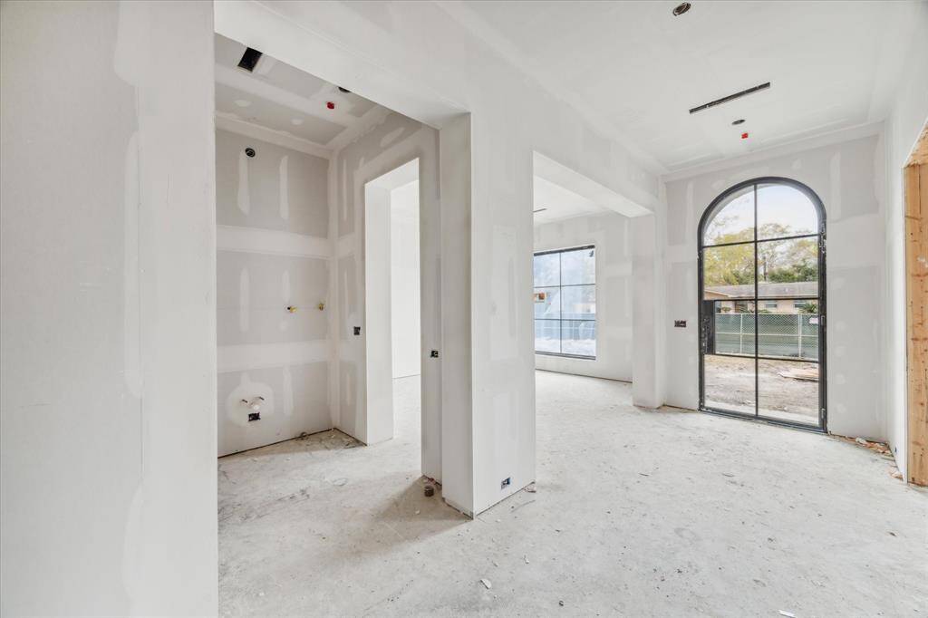 The front facing dining room with adjacent bar area is perfect for gathering for a lovely dinner. Progress Picture March 2025.The bar area to have a sink, wine refrigerator, light sconces and plenty of cabinetry!